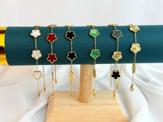 Set of colorful flower-shaped bracelets on a green cushion with a white background