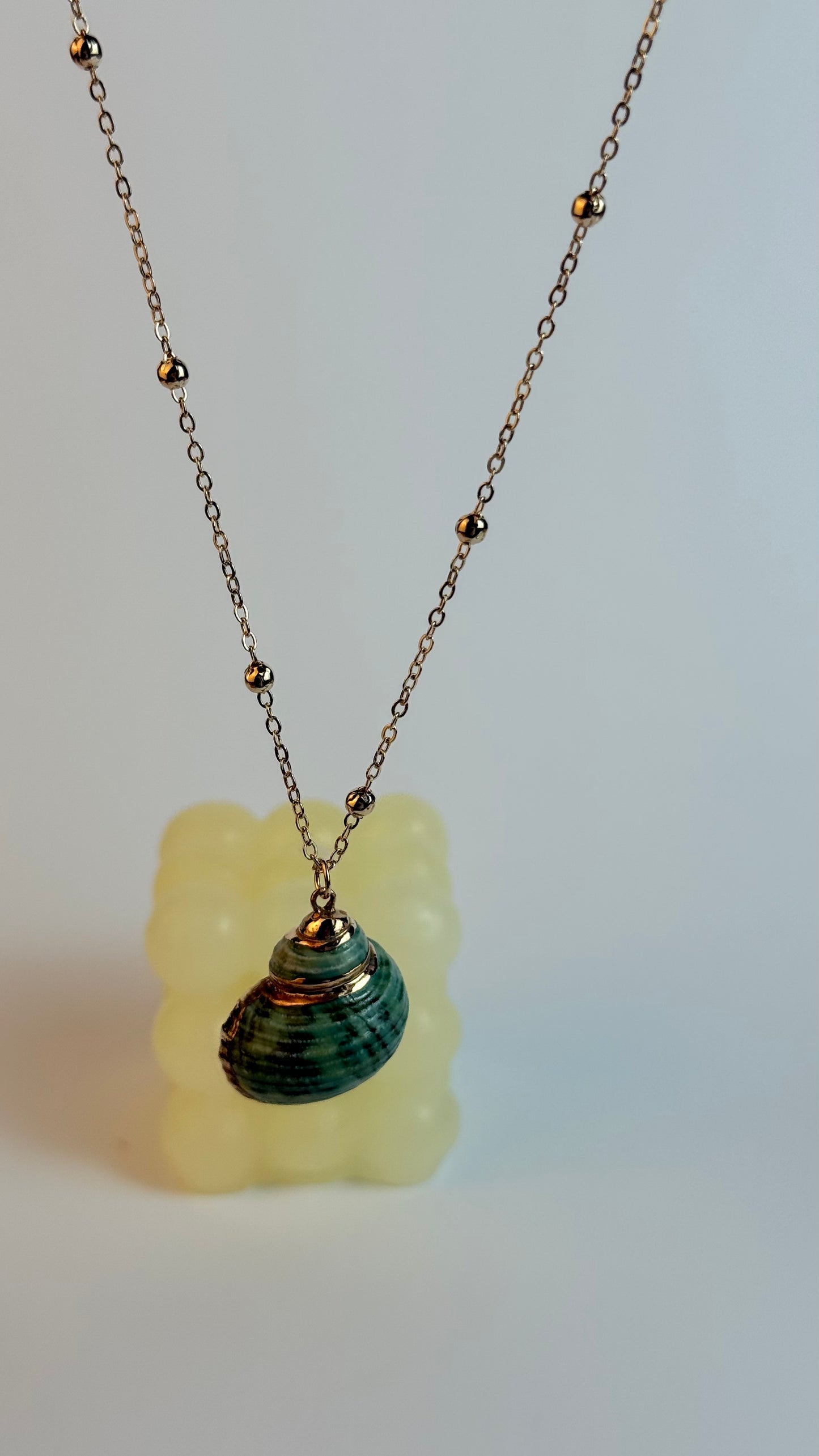 Necklace with a green pendant on a white background