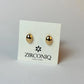 Gold earrings on a Zirconiq branded card against a light gray background