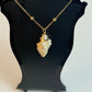 Necklace with a stone pendant on a black stand against a white background