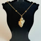 Necklace with a stone pendant on a black bust against a white background