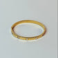 Gold ring with small stones on a light gray background