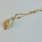 Necklace with a shell pendant on a light gray background