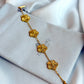 Gold bracelet with floral designs on a Zirconiq branded pouch.