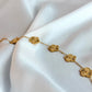 Gold bracelet with floral designs on a white fabric background