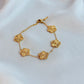 Gold bracelet with floral designs on a white fabric background