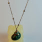 Necklace with a green pendant on a white background