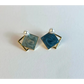 Pair of square earrings with blue centers and gold borders on a white background