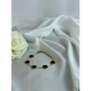 Bracelet with flower-shaped charms on a white fabric background