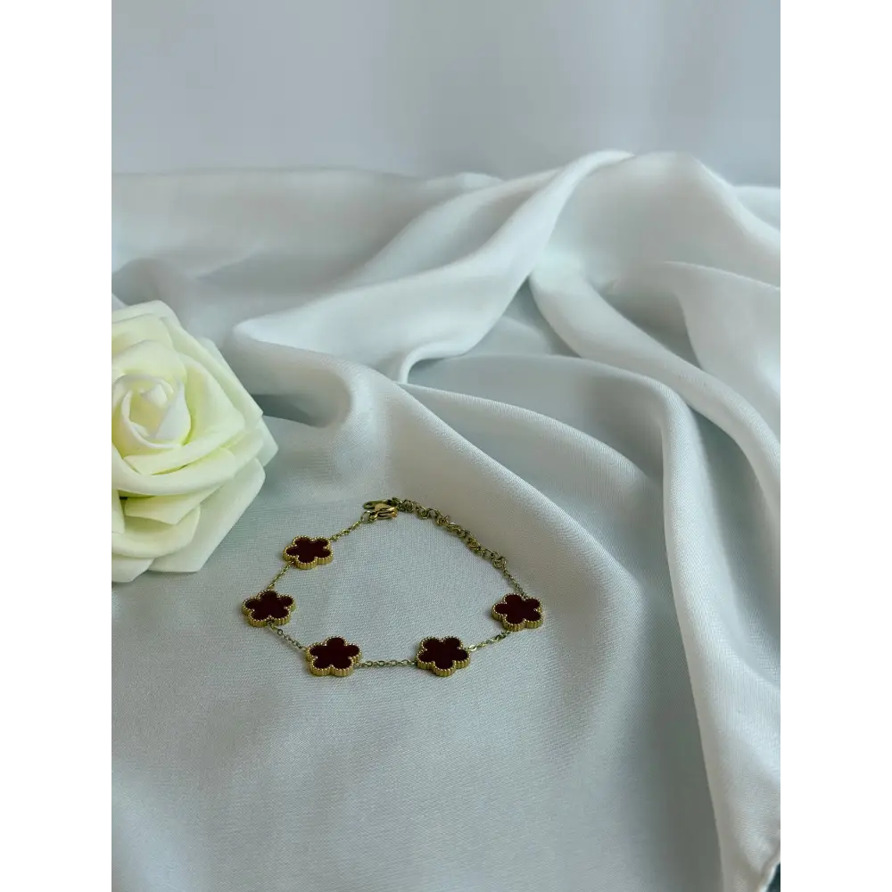Bracelet with flower-shaped charms on a white fabric background