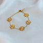 Gold bracelet with floral designs on a white fabric background