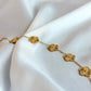 Gold bracelet with floral designs on a white fabric background