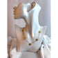 Gold necklace with floral designs on a mannequin bust against a white background