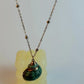 Necklace with a green pendant on a white background