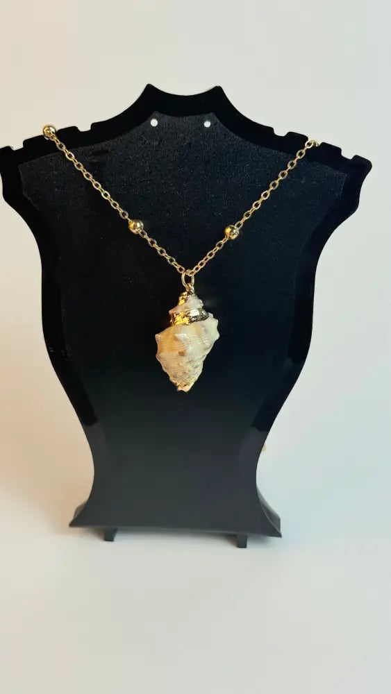 Necklace with a stone pendant on a black stand against a white background