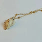 Necklace with a shell pendant on a light gray background